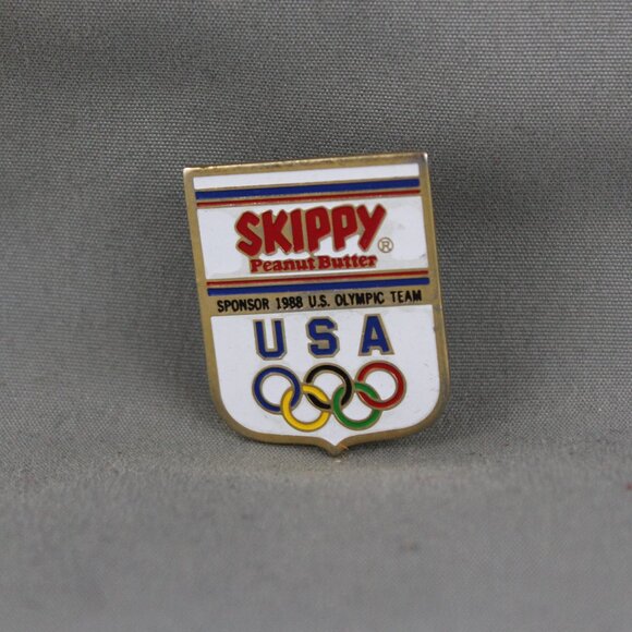 Calgary 88 Olympics Pin - Skippy Peanut Butter Team USA Sponor - Stamped Pin - Picture 1 of 3